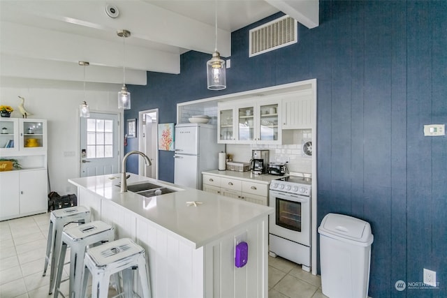 kitchen with white cabinetry, sink, hanging light fixtures, white appliances, and light tile patterned flooring