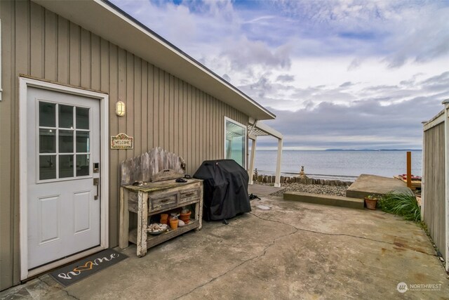 view of patio / terrace with a grill and a water view