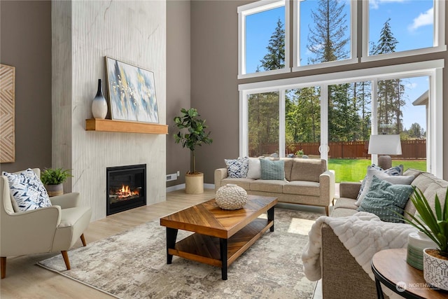 living room featuring a towering ceiling, a wealth of natural light, and hardwood / wood-style floors