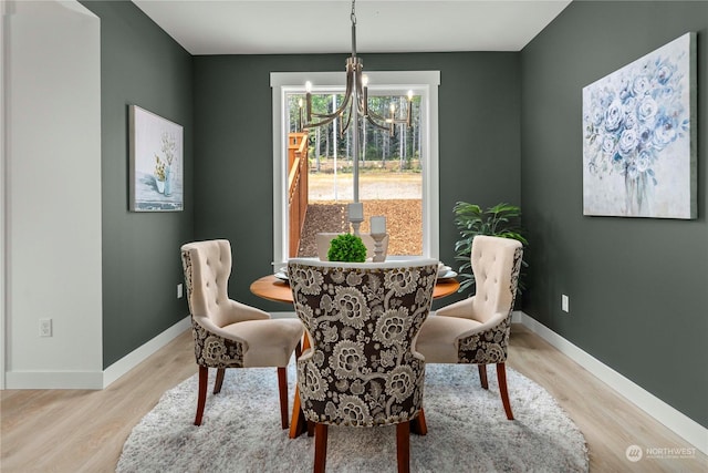 dining space featuring light hardwood / wood-style floors and a chandelier