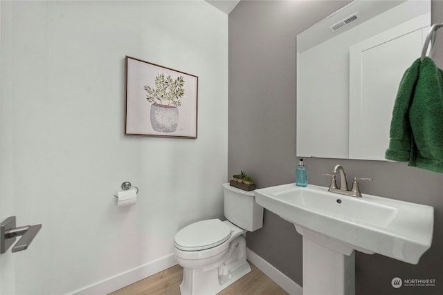 bathroom with sink, toilet, and wood-type flooring