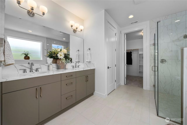 bathroom with tile patterned flooring, vanity, and walk in shower