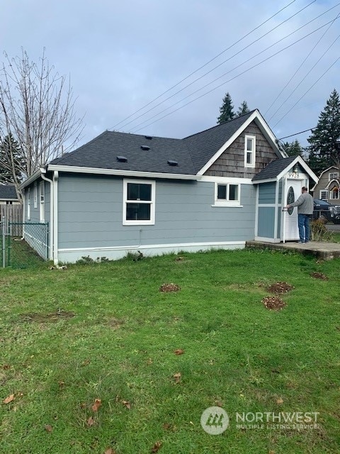 back of house with a lawn