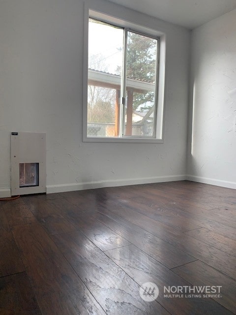 unfurnished living room with dark wood-type flooring