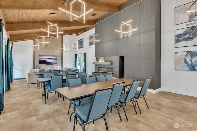 dining space with beam ceiling, wood ceiling, a fireplace, and high vaulted ceiling