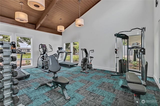 gym with carpet flooring, a wealth of natural light, wooden ceiling, and high vaulted ceiling