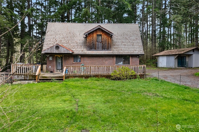 view of front of home with a deck, a front lawn, and a storage unit