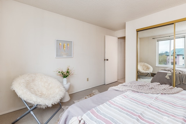 carpeted bedroom featuring a closet and a textured ceiling