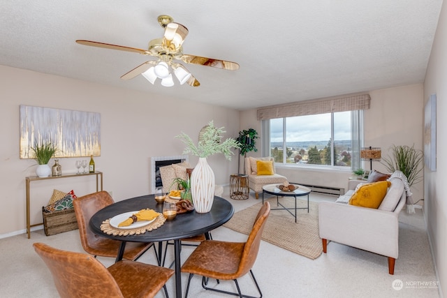 carpeted dining area with a textured ceiling and ceiling fan