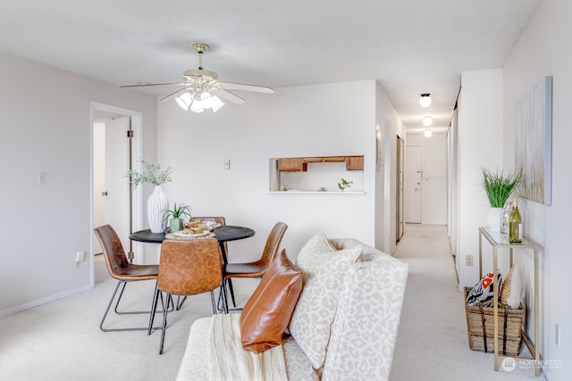 dining area featuring ceiling fan and light carpet