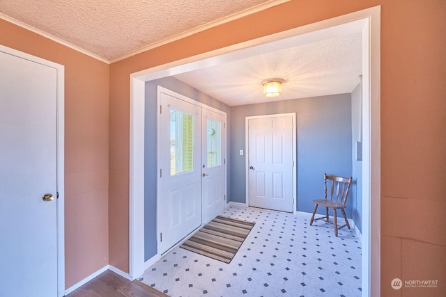 entrance foyer featuring a textured ceiling, light hardwood / wood-style flooring, and crown molding