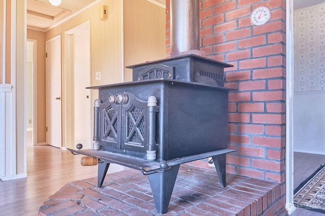 details with a wood stove, ornamental molding, hardwood / wood-style flooring, and a textured ceiling