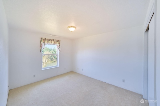 empty room featuring light colored carpet