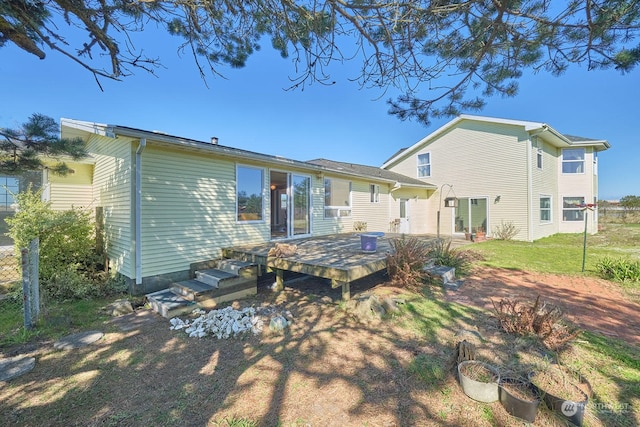 back of property featuring a wooden deck and a yard