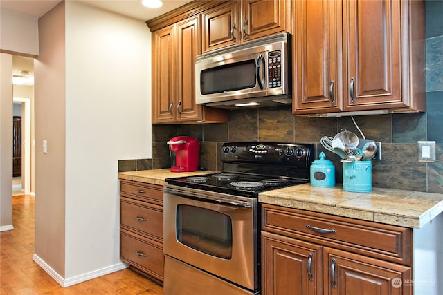 kitchen featuring backsplash, light hardwood / wood-style floors, and electric range