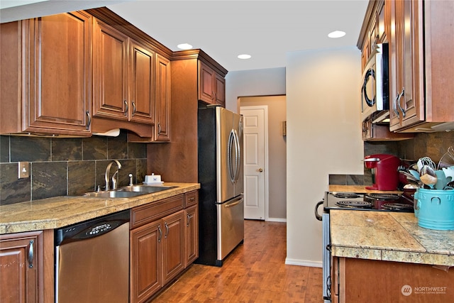 kitchen featuring backsplash, sink, light wood-type flooring, and stainless steel appliances