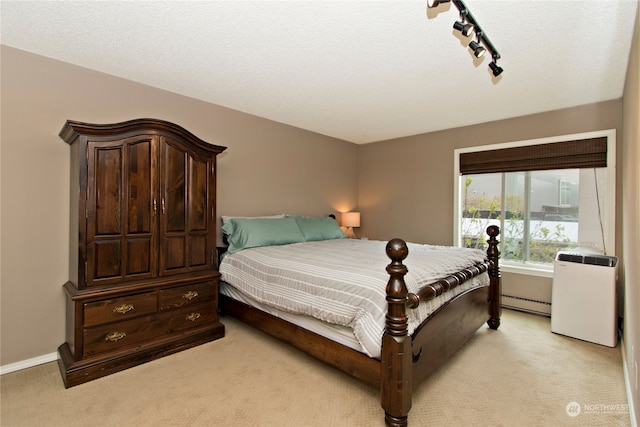 bedroom featuring light colored carpet, a textured ceiling, and baseboard heating