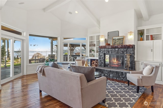 living room featuring built in features, a stone fireplace, dark hardwood / wood-style flooring, and beamed ceiling