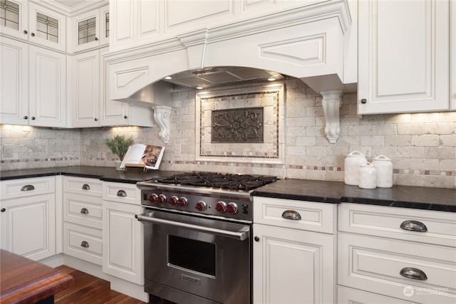 kitchen with backsplash, premium range, white cabinets, and dark hardwood / wood-style flooring