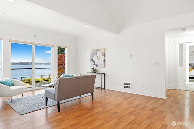 living room featuring light hardwood / wood-style floors and a water view