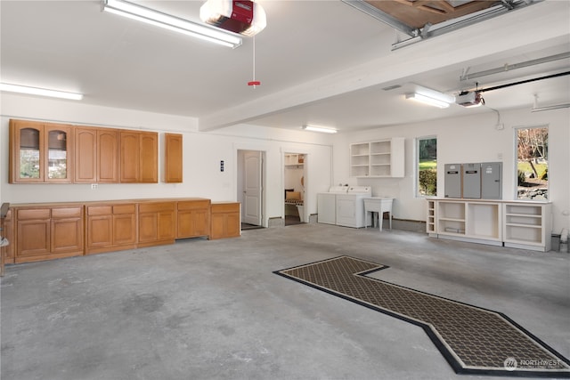 garage featuring sink, independent washer and dryer, and a garage door opener