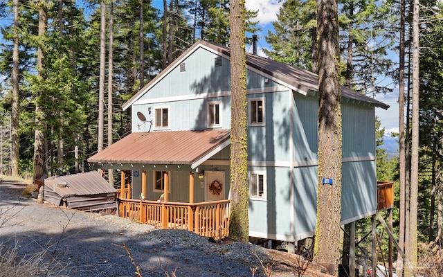 chalet / cabin featuring covered porch and metal roof