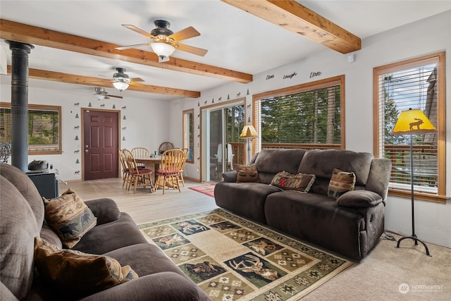 living room with beamed ceiling, light hardwood / wood-style floors, a wealth of natural light, and ceiling fan