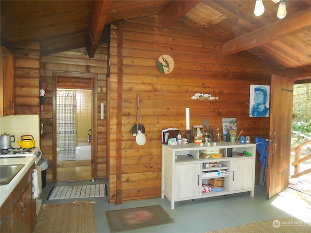 kitchen with wood ceiling, lofted ceiling with beams, and log walls