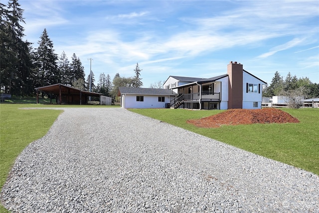 view of front facade featuring a front yard and a carport