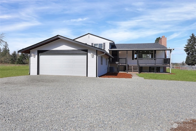 view of front of home with a porch, central AC, and a garage