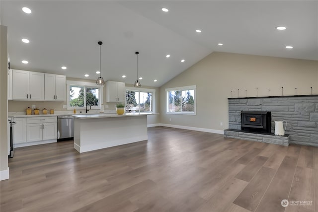 kitchen featuring a fireplace, white cabinets, dishwasher, hardwood / wood-style floors, and hanging light fixtures