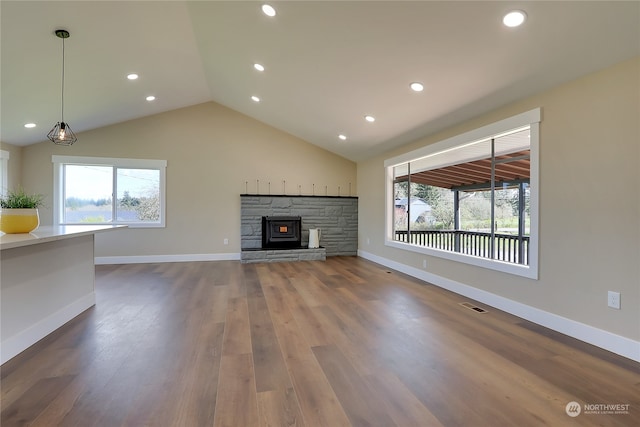 unfurnished living room featuring plenty of natural light, a fireplace, and dark hardwood / wood-style floors