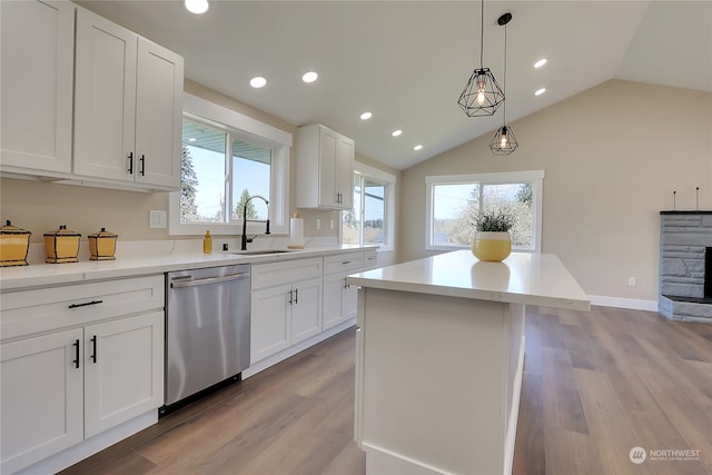 kitchen with vaulted ceiling, dishwasher, white cabinetry, pendant lighting, and light wood-type flooring