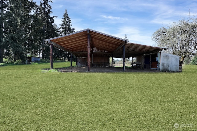 view of property's community featuring an outdoor structure and a lawn