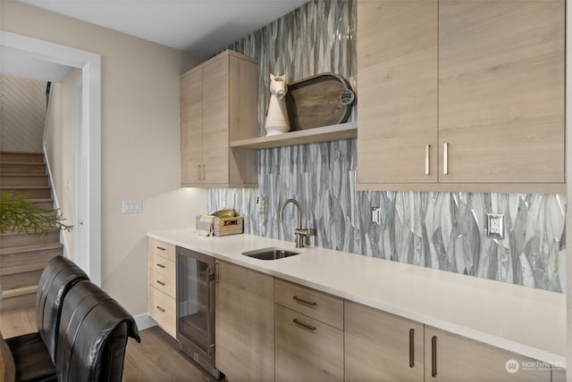 kitchen with light brown cabinets, tasteful backsplash, wine cooler, sink, and dark hardwood / wood-style flooring