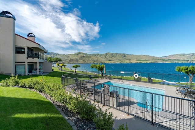 view of pool featuring a yard and a water and mountain view