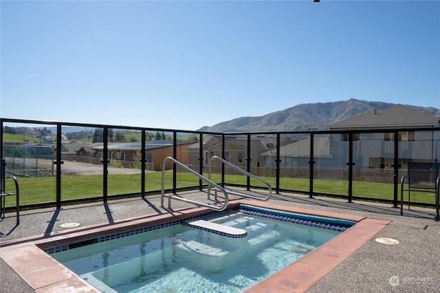 view of pool with a mountain view, a yard, and an in ground hot tub