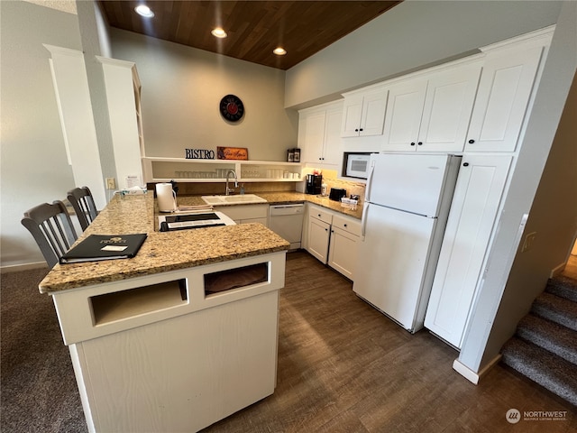 kitchen featuring kitchen peninsula, white cabinets, white appliances, and sink