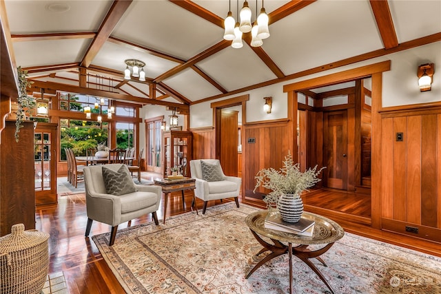 sitting room featuring vaulted ceiling with beams, dark hardwood / wood-style flooring, a chandelier, and wooden walls