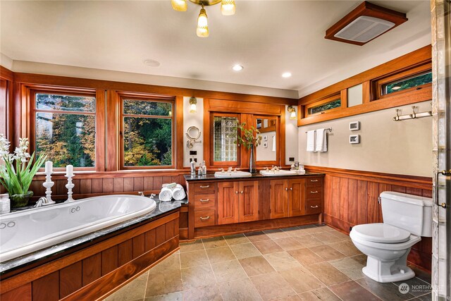 bathroom featuring a bathing tub, dual bowl vanity, toilet, and tile flooring