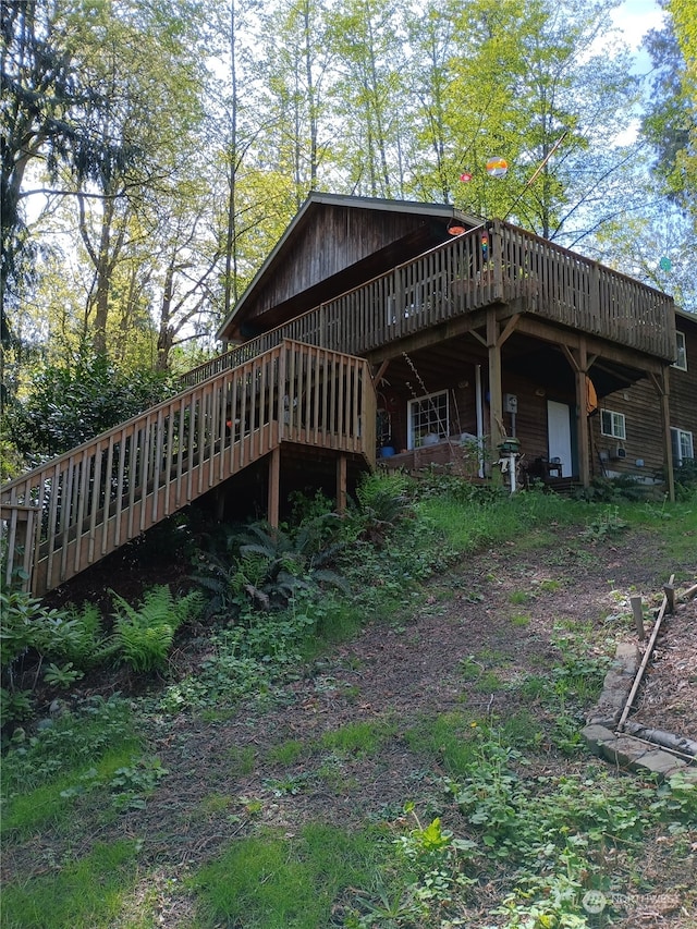 rear view of house featuring a wooden deck