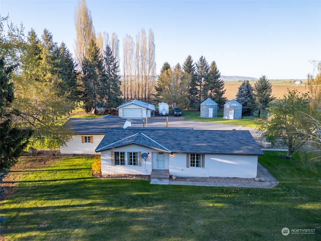 view of front of house with a front lawn and a storage unit