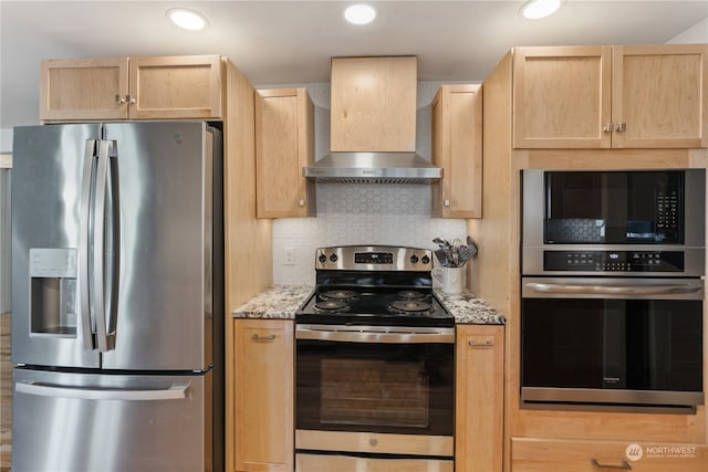 kitchen with appliances with stainless steel finishes, wall chimney range hood, backsplash, and light brown cabinets