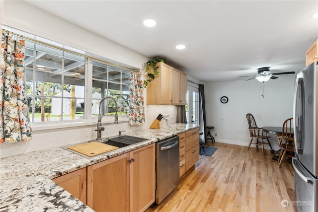 kitchen featuring backsplash, a wealth of natural light, and light wood-type flooring