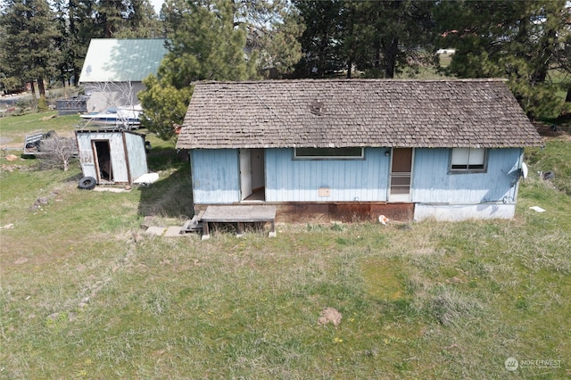 view of front of home with an outdoor structure and a front yard