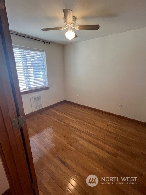 unfurnished room with ceiling fan and dark wood-type flooring