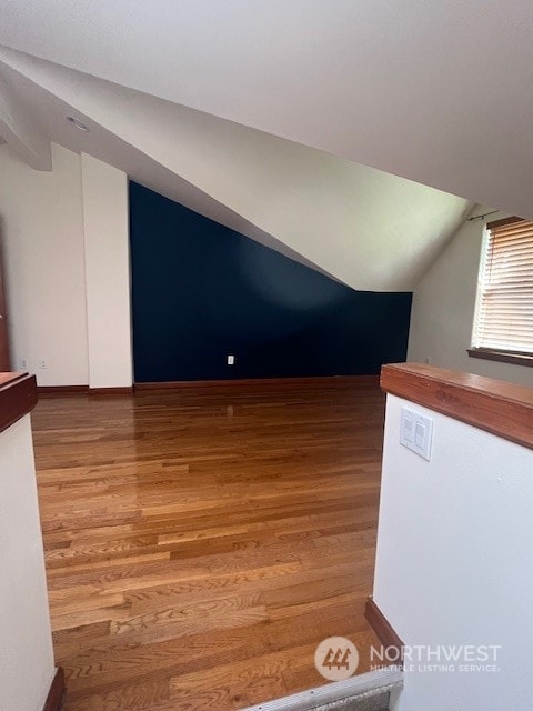 unfurnished room with lofted ceiling and hardwood / wood-style flooring