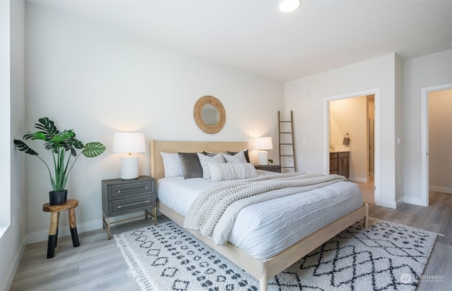 bedroom with hardwood / wood-style floors and ensuite bath