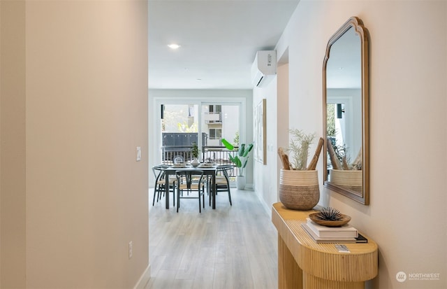 hall featuring a wall mounted air conditioner and light wood-type flooring