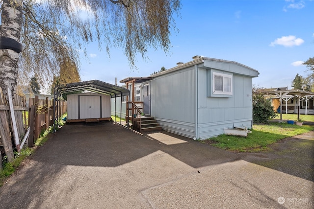 view of side of property featuring a carport and a shed